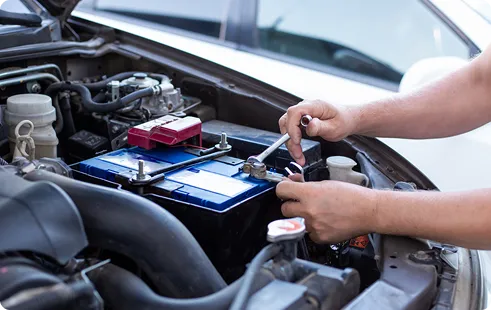 Technician tightening a car battery terminal